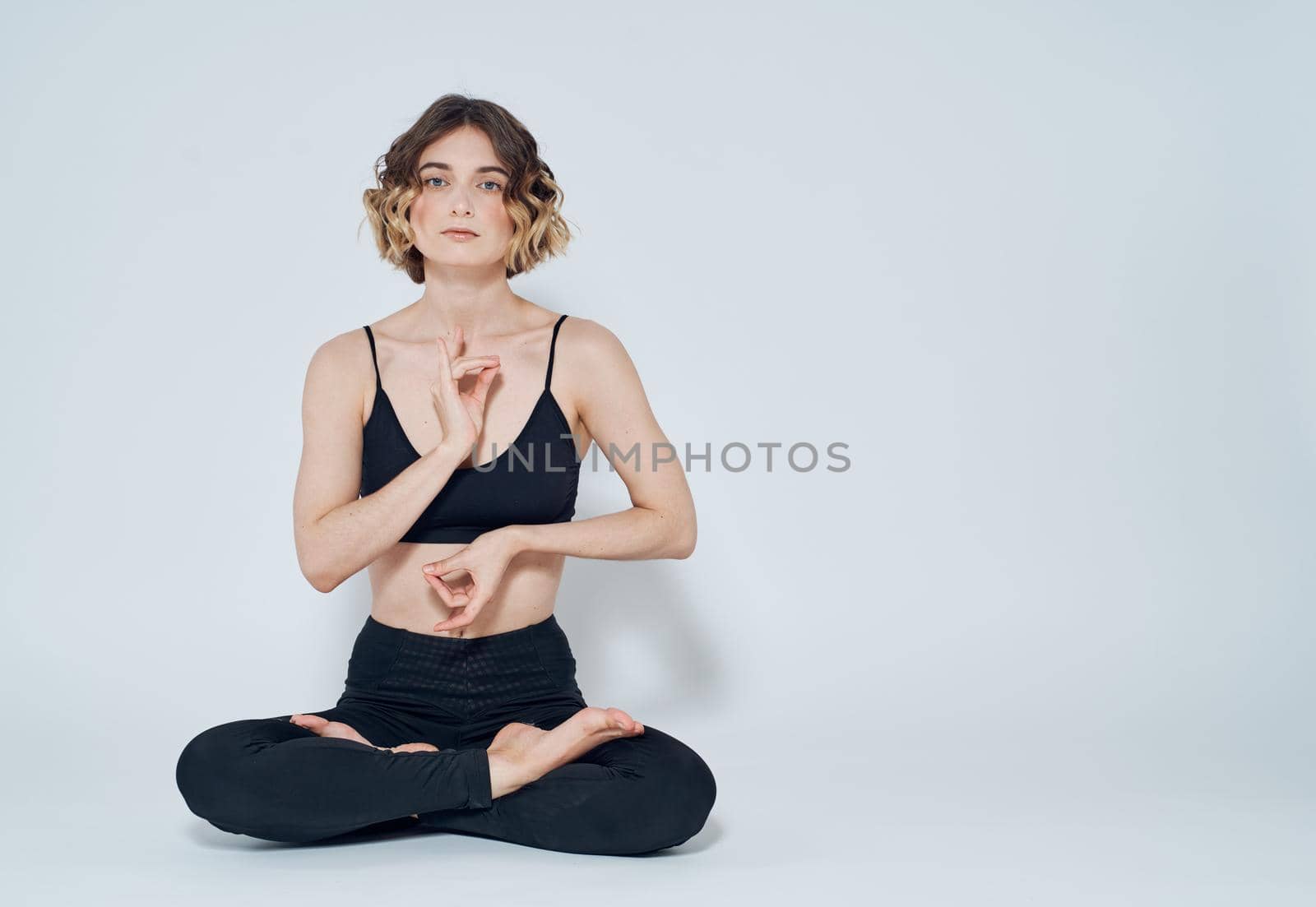 Woman meditates on a light background yoga asana. High quality photo