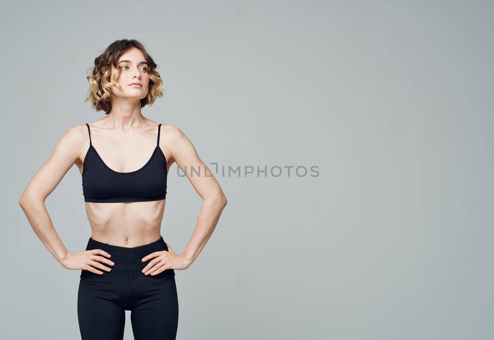 A strange woman in lollipops is engaged in fitness on a gray background by SHOTPRIME