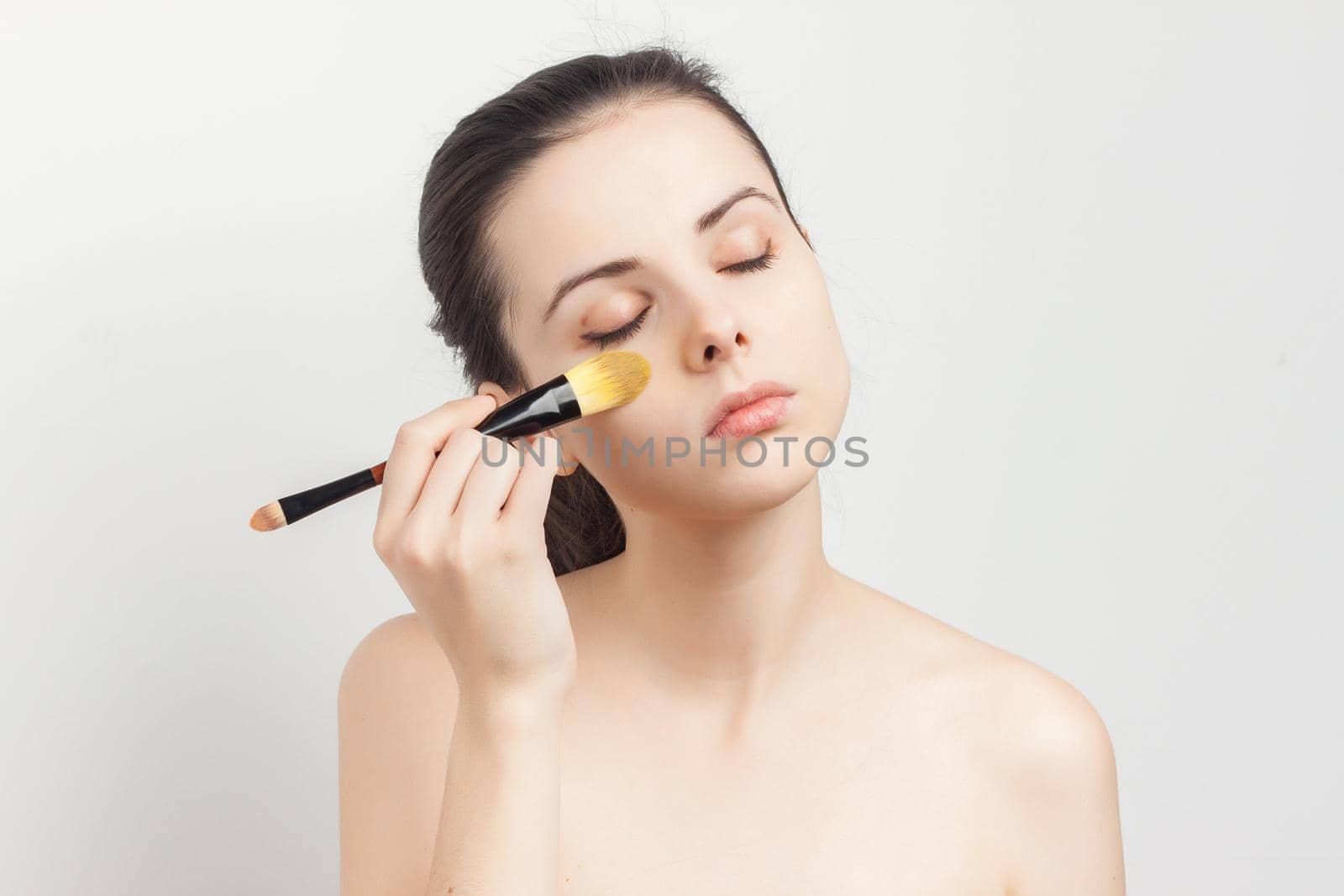 brunette brushing cream on face skin care cropped view. High quality photo