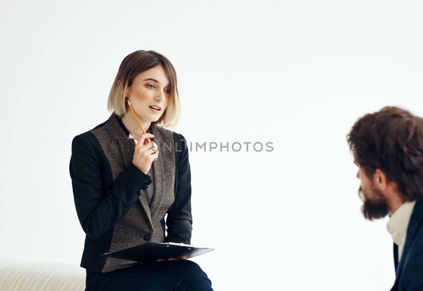 Business woman in a classic suit and a man in a jacket on a light background opposite each other. High quality photo