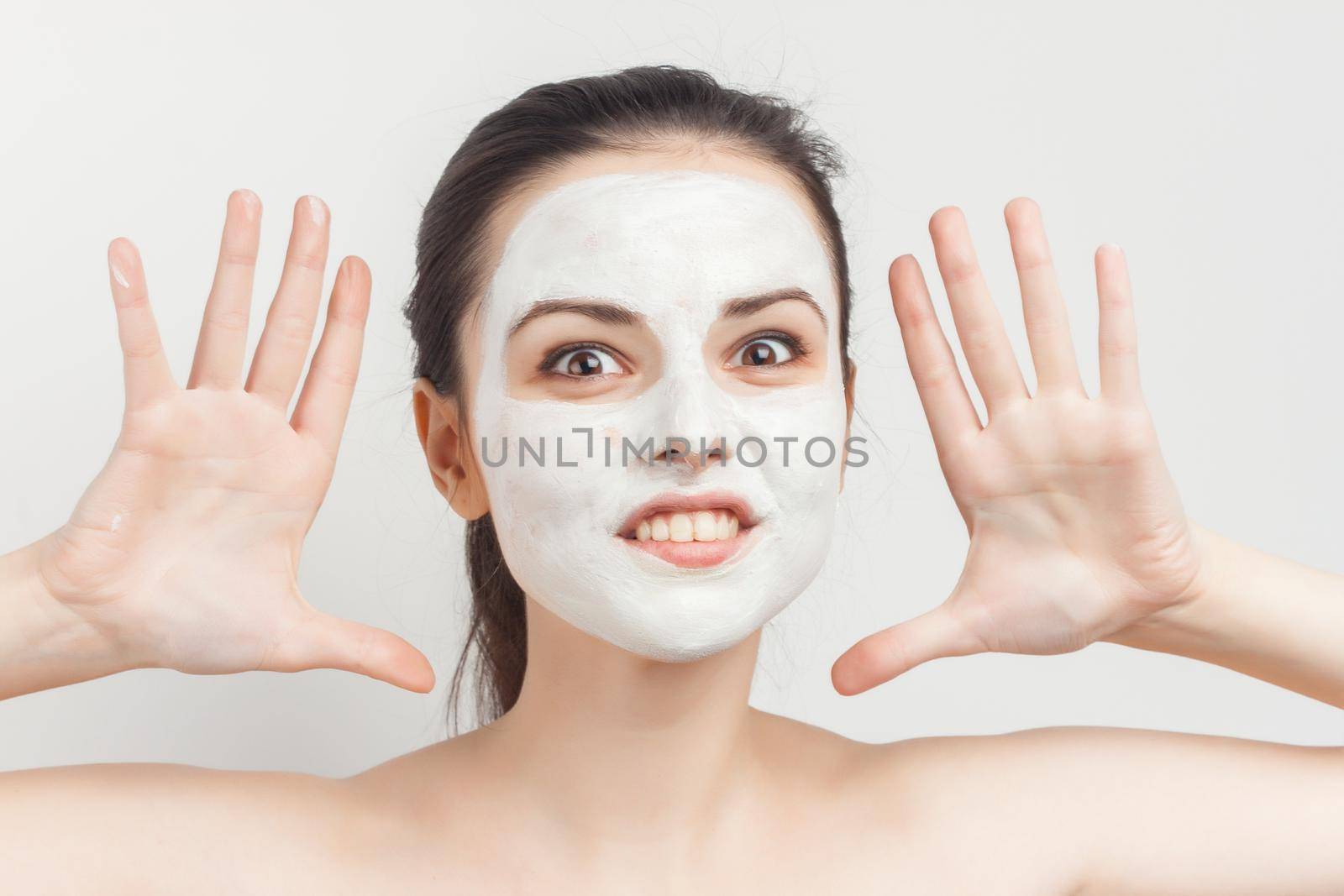 perky brunette naked shoulders cream facial mask skin care treatments. High quality photo