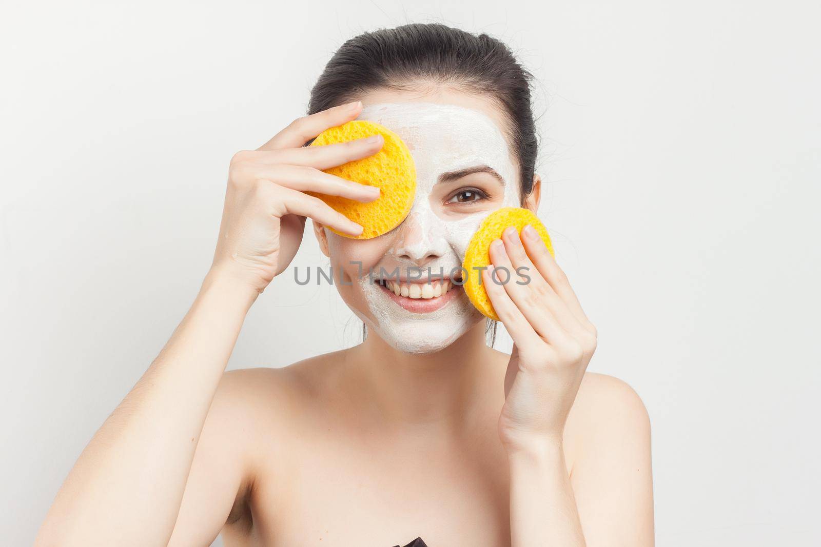 brunette naked shoulders face cream skin care. High quality photo