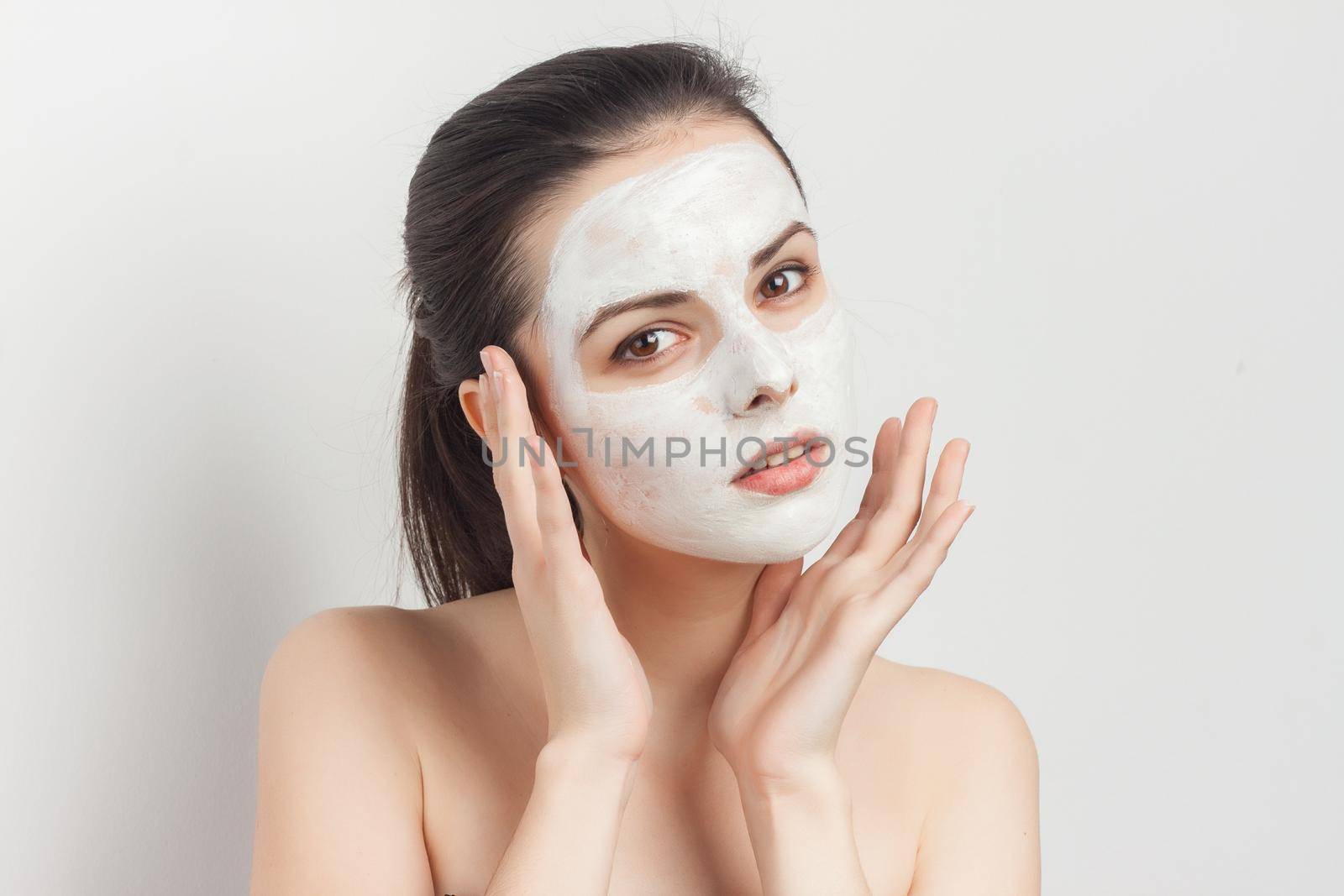 attractive brunette cream mask on face brush for applying cropped look by SHOTPRIME