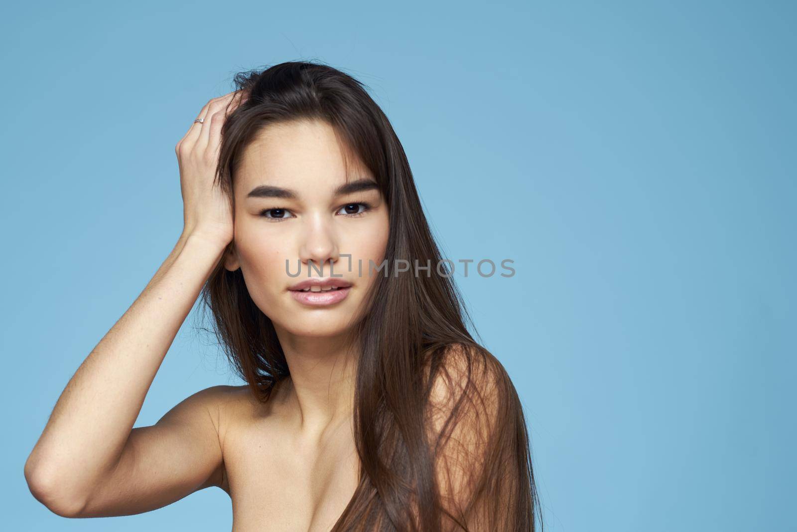 beautiful woman naked shoulders clear skin close-up skin care blue background by SHOTPRIME