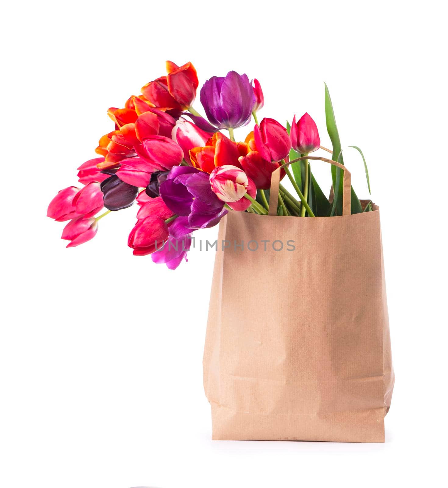 colorful tulips in a paper bag on a white background