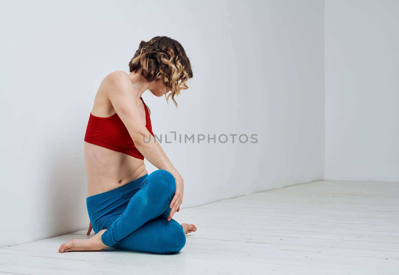 Blue leggings red t-shirt woman yoga asana twisting by SHOTPRIME