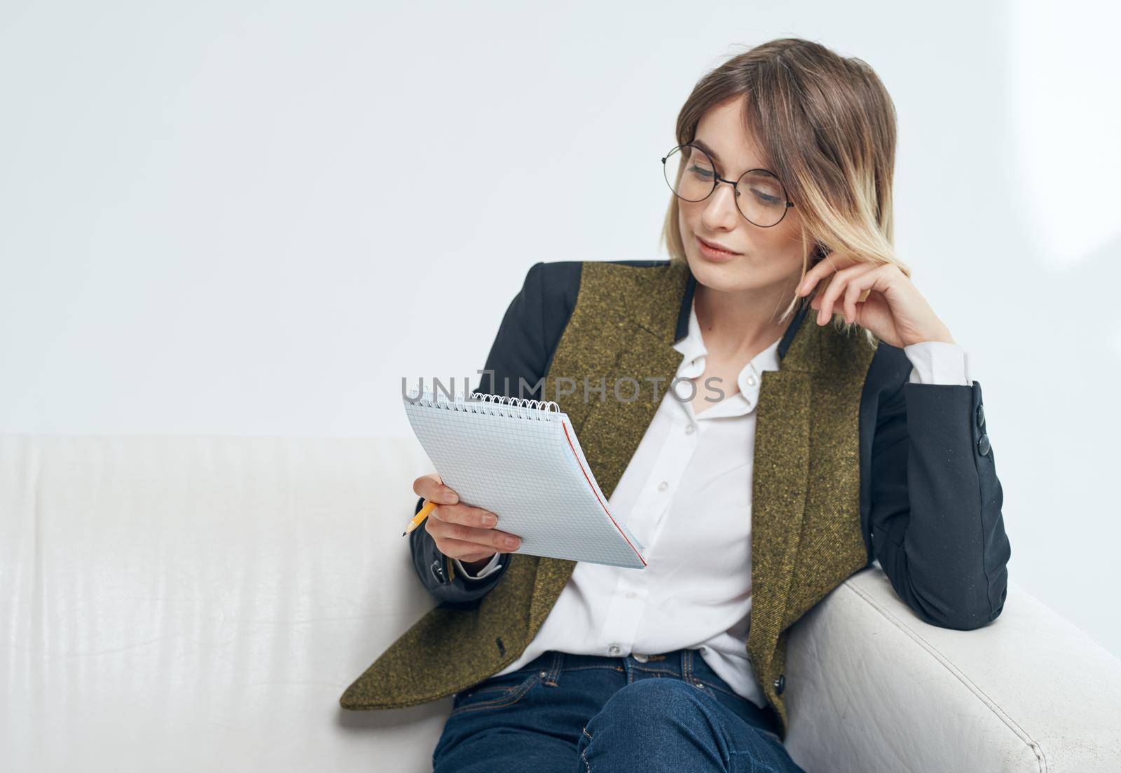 Business woman with documents and in a fashionable jacket on a light background by SHOTPRIME