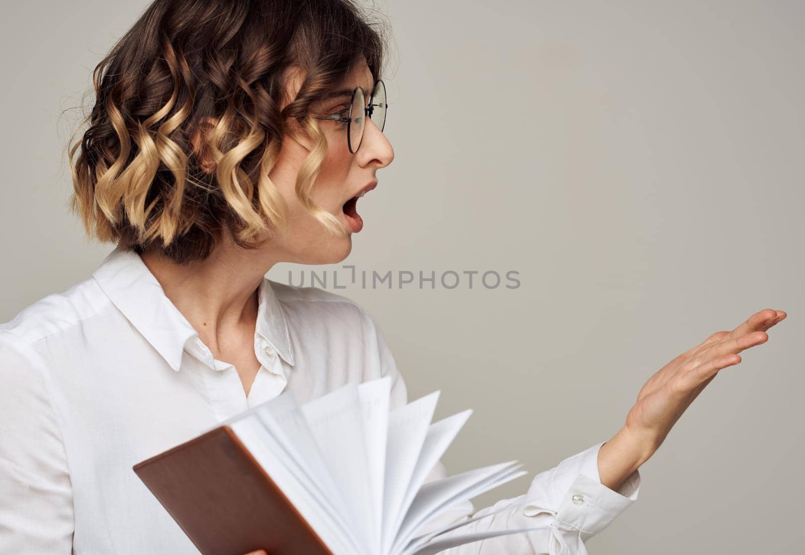 Business woman with a book in her hands on a gray background Copy Space by SHOTPRIME