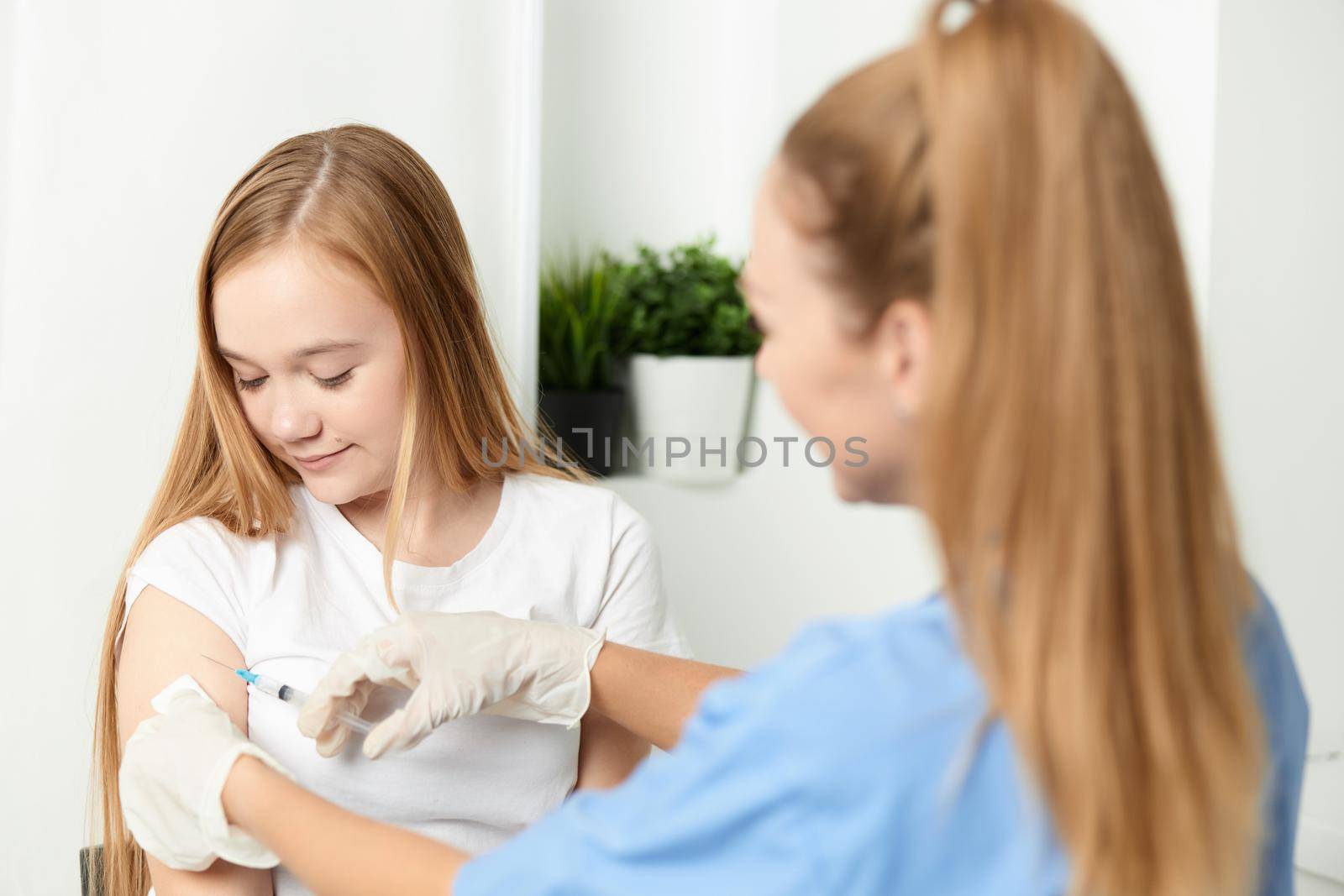 female doctor giving an injection to the girl's hand vaccination health. High quality photo