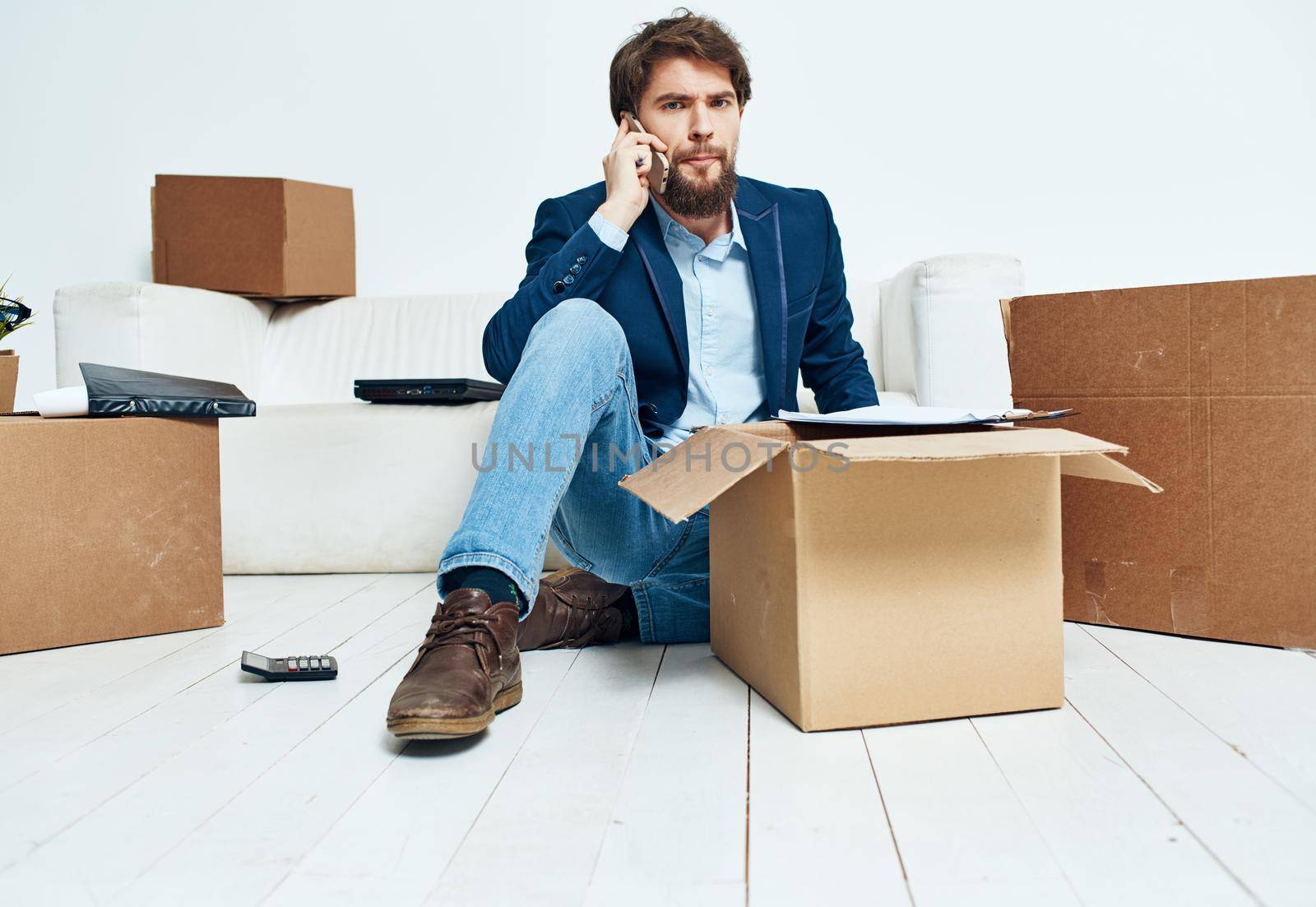 Man talking on the phone boxes with belongings moving unpacking official. High quality photo