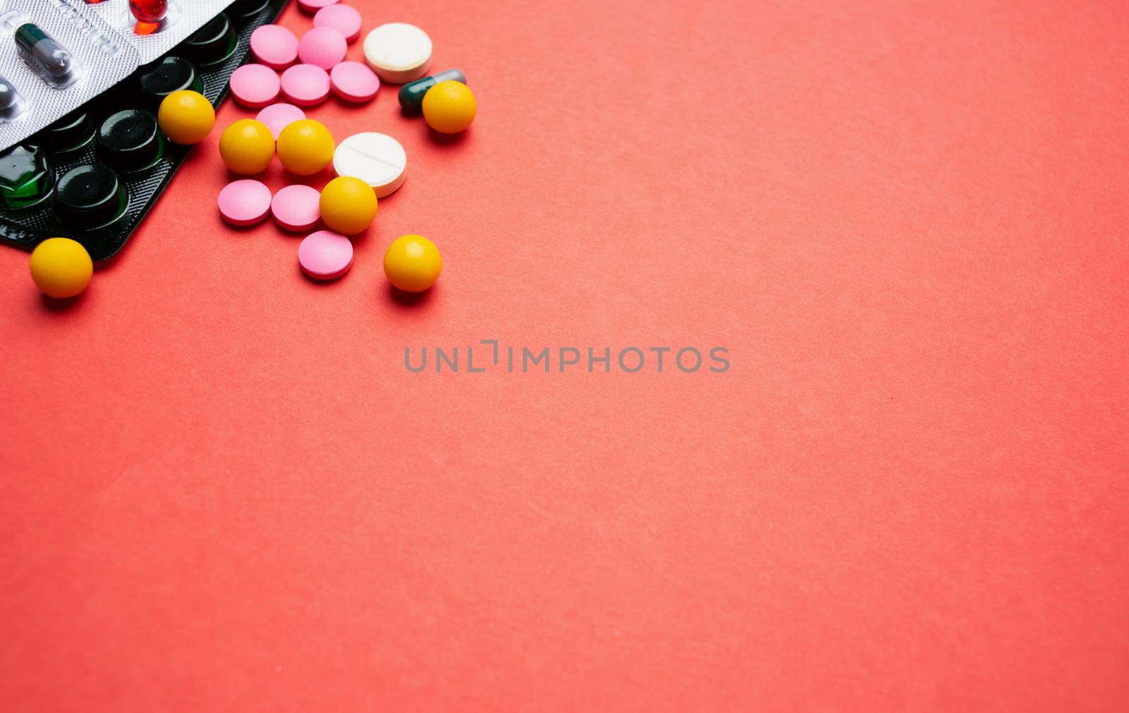 multicolored pills on red background medicine health. High quality photo