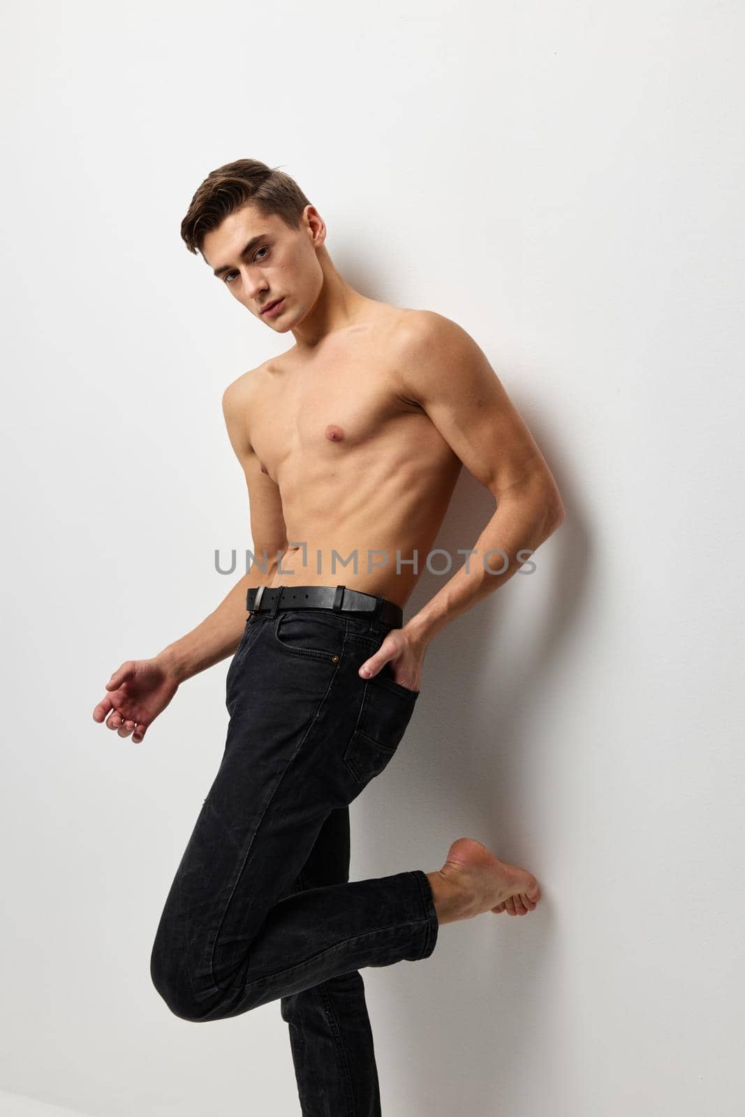 A man with a naked torso in black trousers posing portrait of self-confidence by SHOTPRIME
