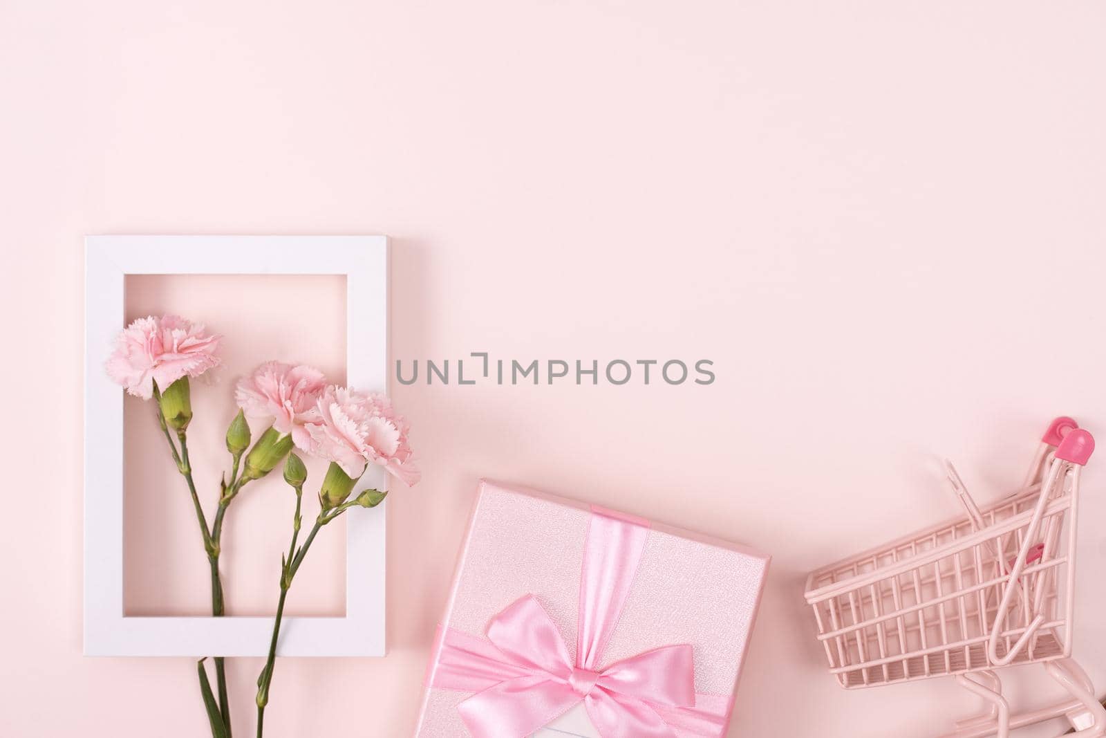 Concept of Mother's day holiday greeting design with carnation bouquet and gift on pink background