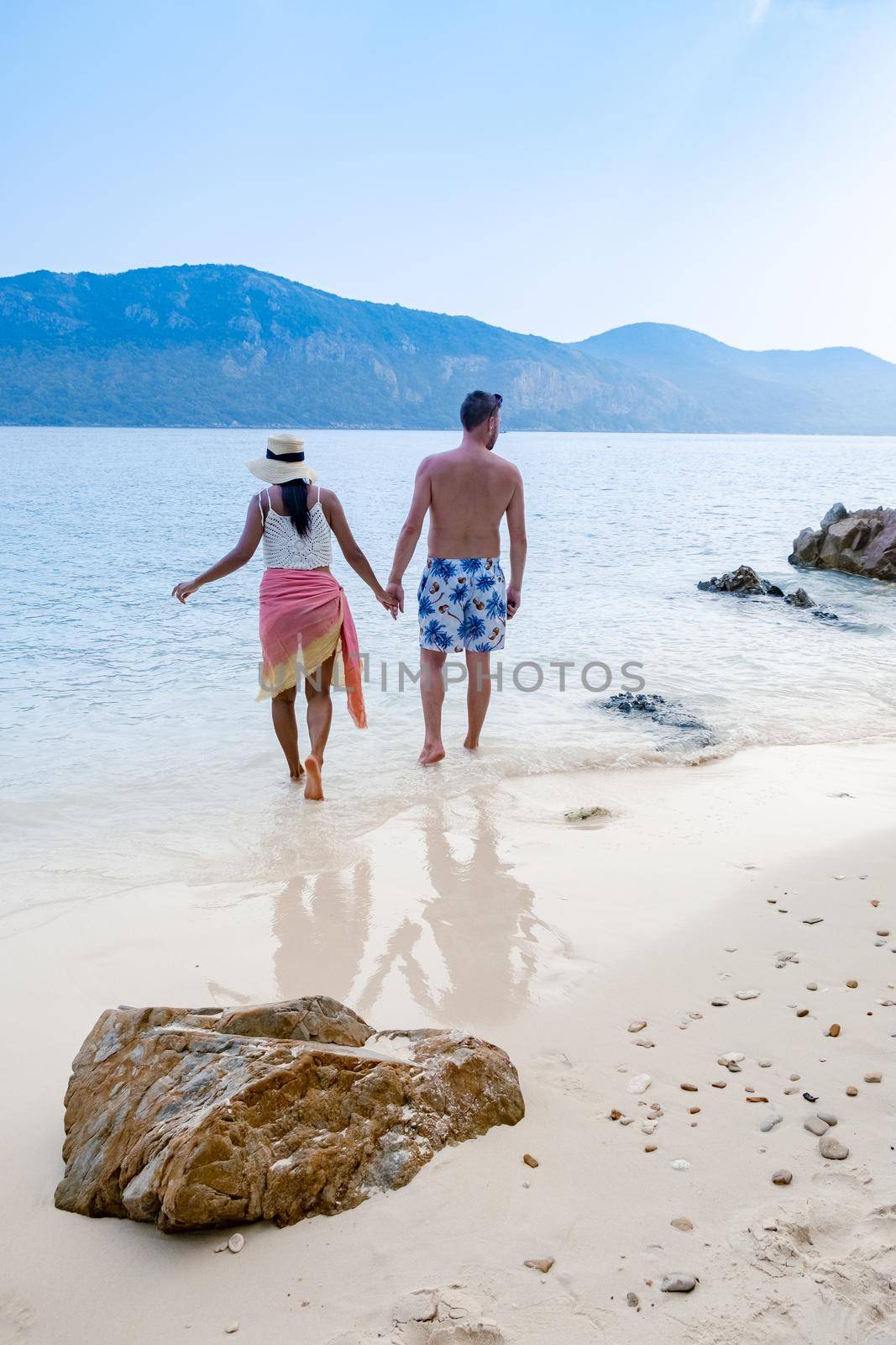 Couple from behind on the backside looking out over ocean of tropical Island, beautiful tropical island beach - Koh Kham, Trat Thailand Pattaya Asia, couple relax on tropical Island by fokkebok
