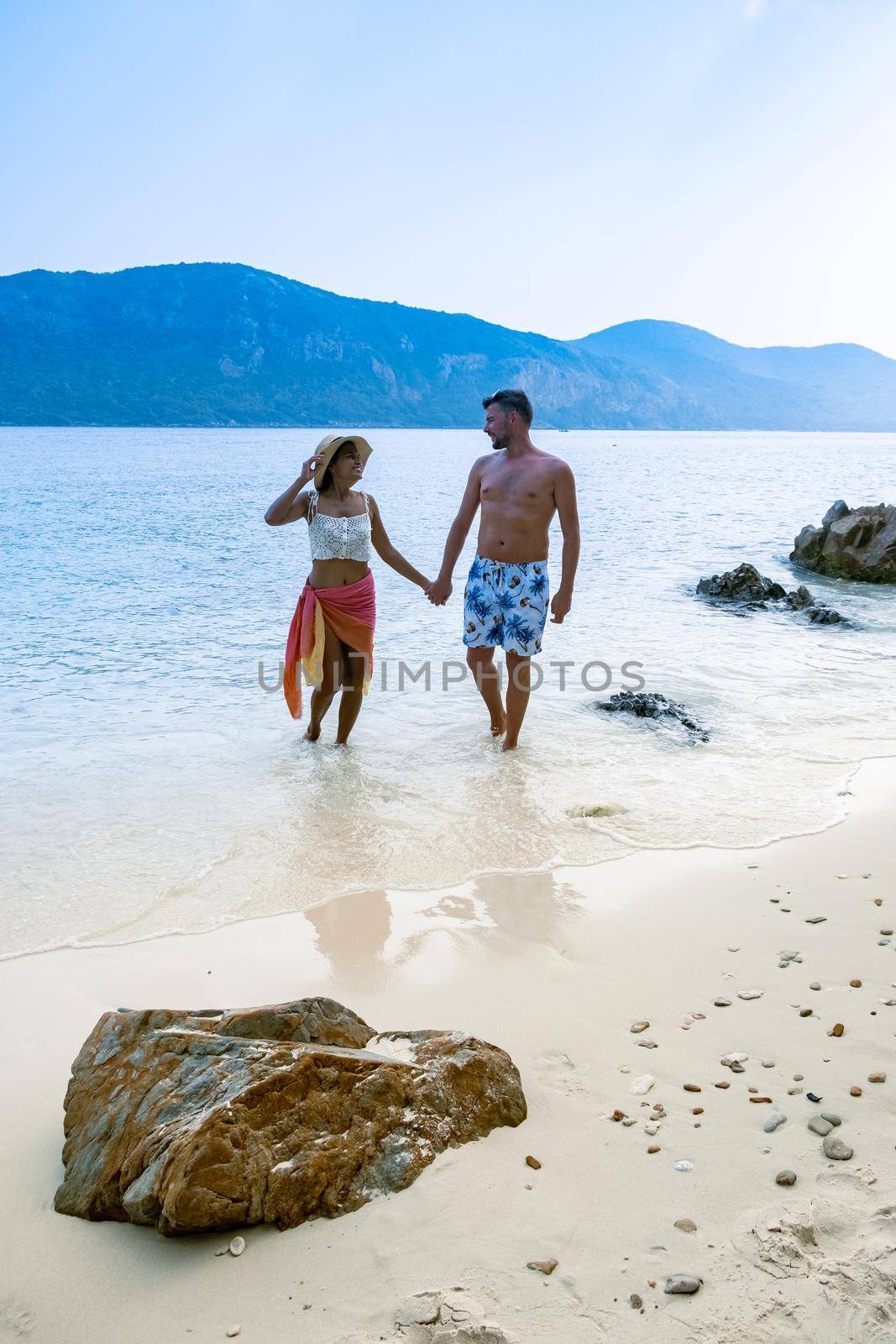 Couple from behind on the backside looking out over ocean of tropical Island, beautiful tropical island beach - Koh Kham, Trat Thailand Pattaya Asia, couple relax on tropical Island by fokkebok