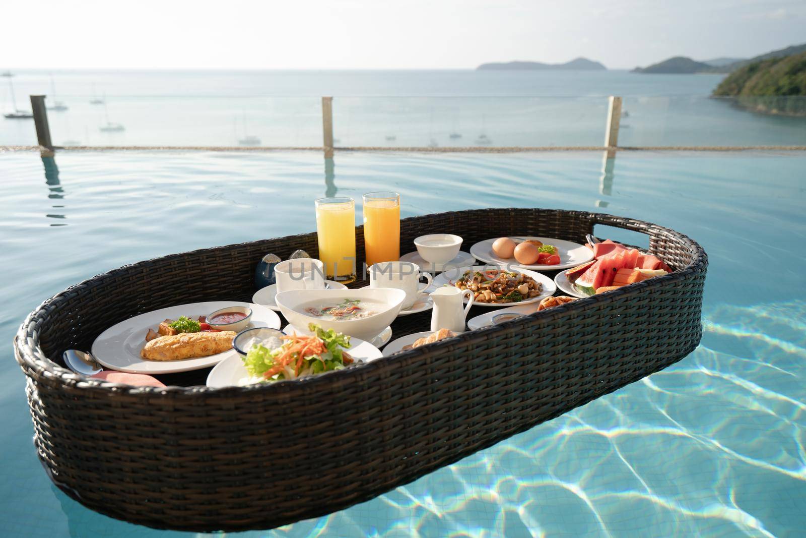 Breakfast set in tray in swimming pool, floating breakfast in tropical resort villa with ocean view. by sirawit99