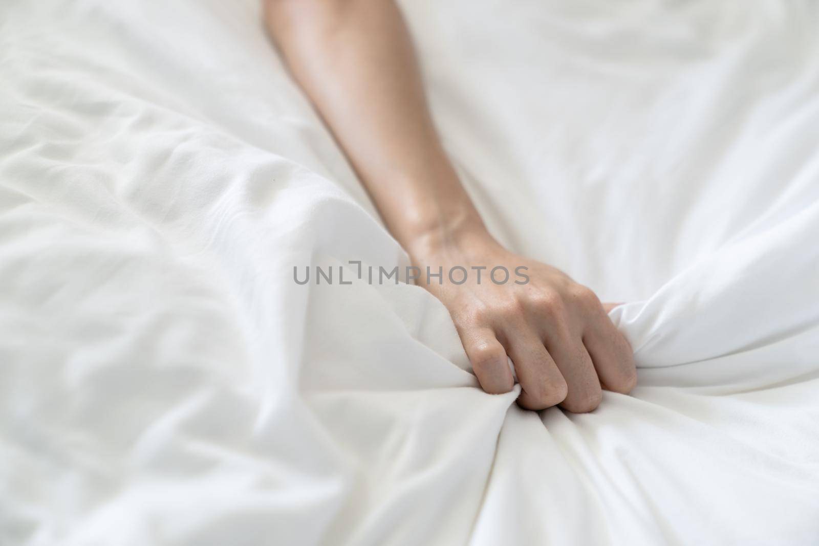 Women hand pulling or grasping white sheets. Hand sign orgasm of woman on white bed sheet. by sirawit99