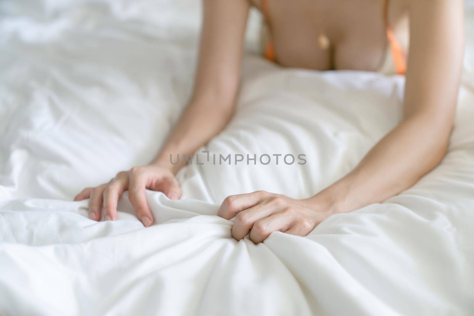 Woman hand grasping white sheet. Couple making love or having sex in bedroom. by sirawit99