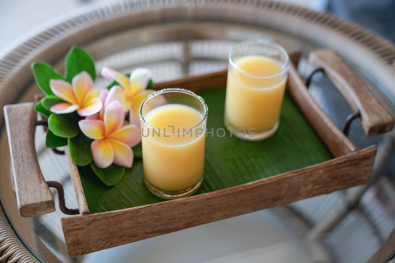 Passion fruit ice cocktail drink on banana leaf and wooden tray.