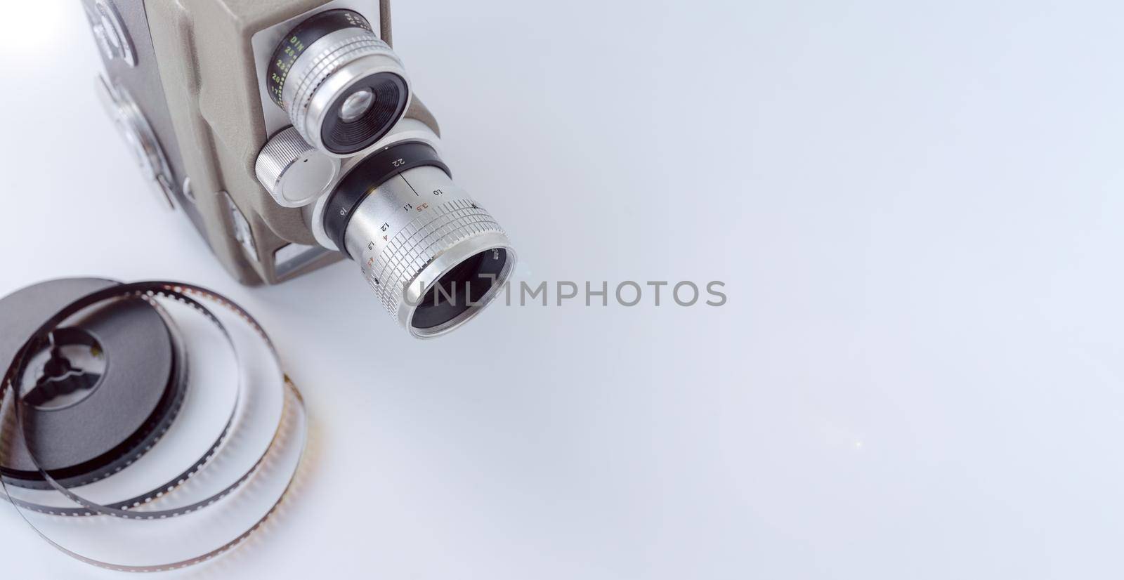 Vintage 8mm camera with 8mm reel on white background.