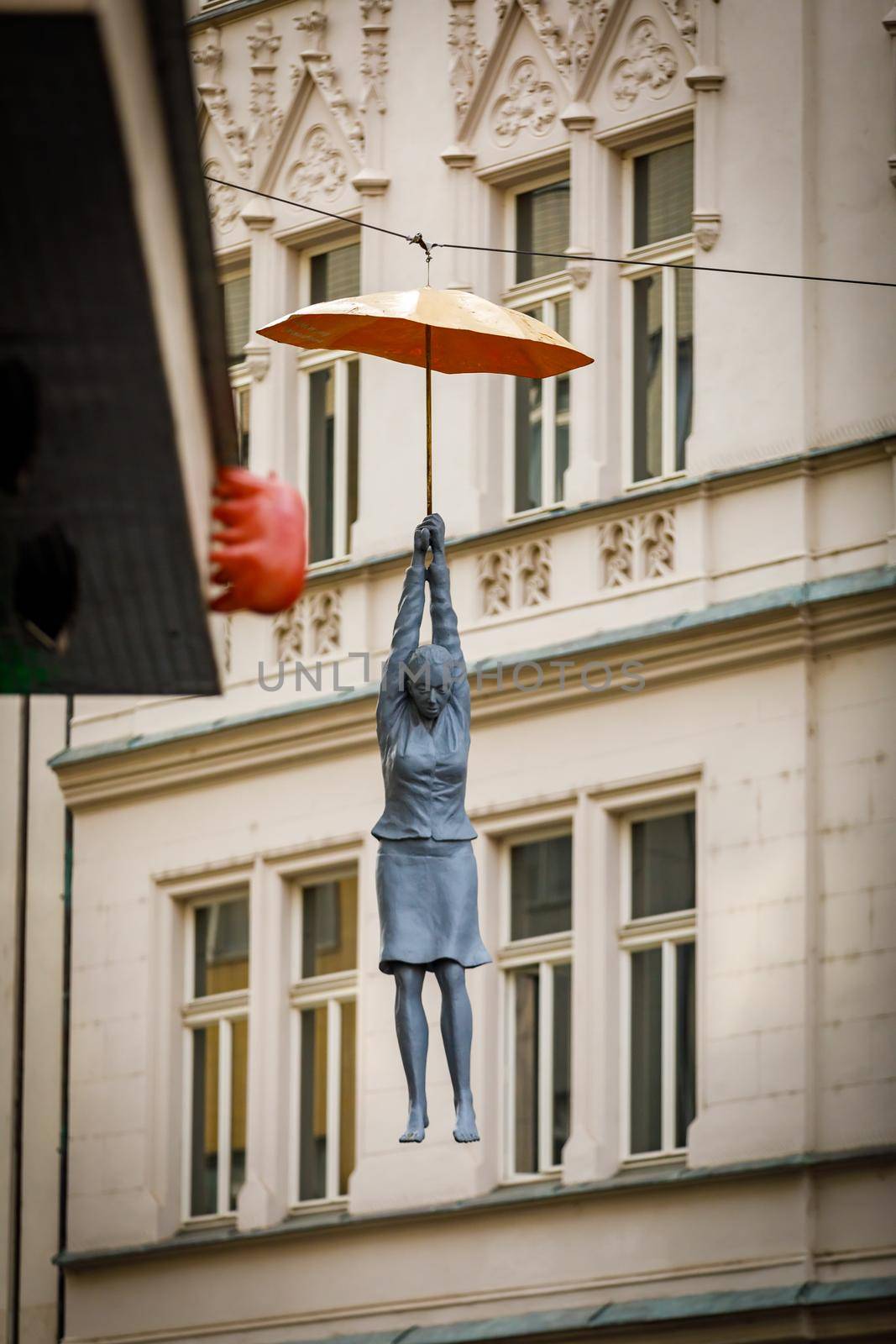 Prague, Czech Republic - April 14, 2018. Sculpture of a woman hanging from an umbrella in Prague. Local landmark
