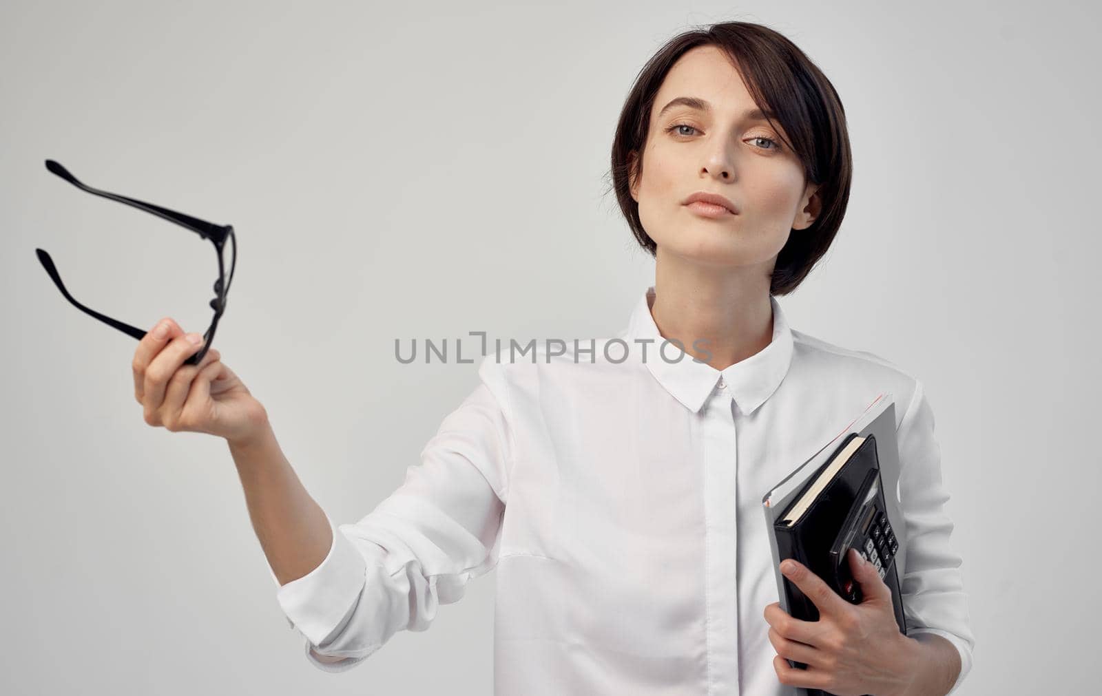 Business woman in glasses documents or in hands on light background by SHOTPRIME