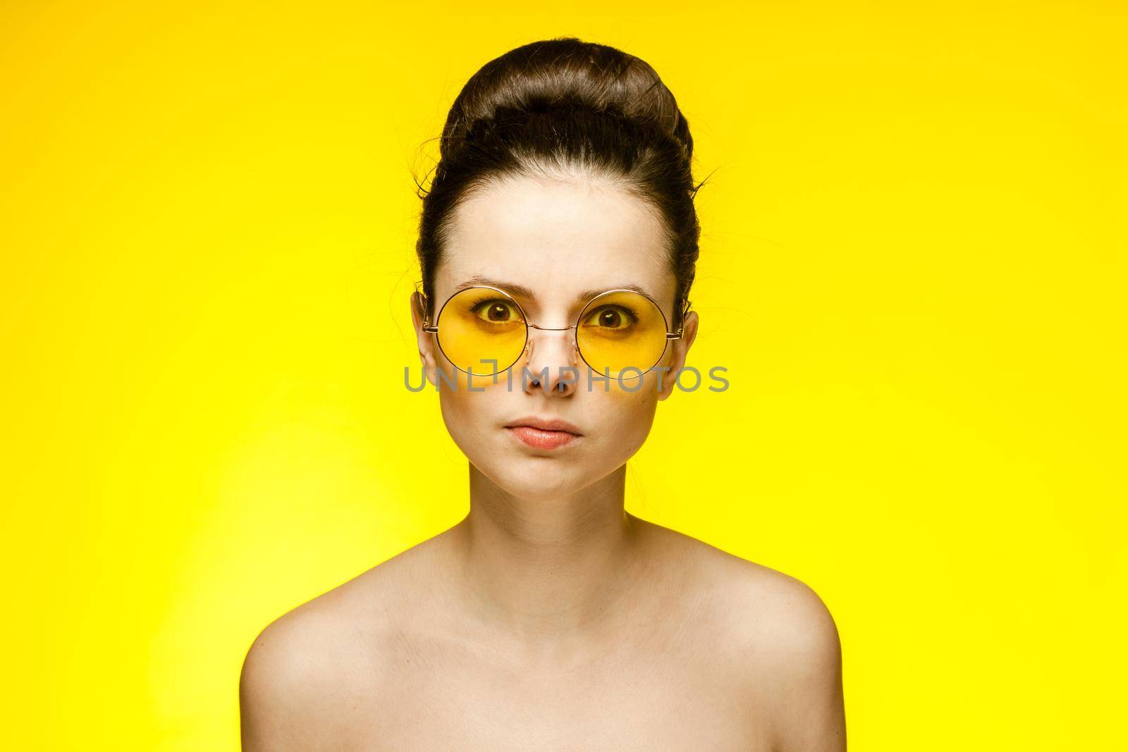 pretty woman with bare shoulders emotions fashionable yellow glasses cropped view. High quality photo