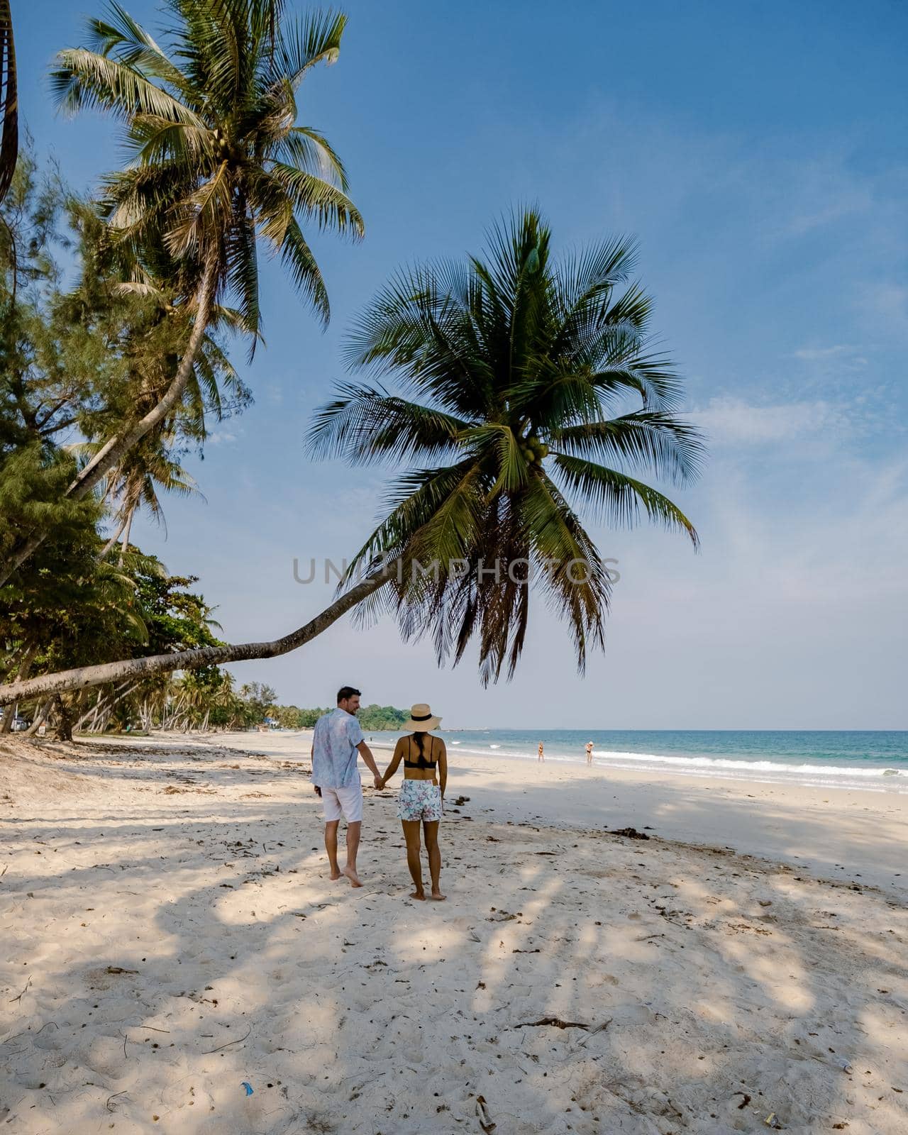 couple on vacation in Thailand, Chumpon province , white tropical beach with palm trees, Wua Laen beach Chumphon area Thailand, palm tree hanging over the beach with couple on vacation in Thailand by fokkebok