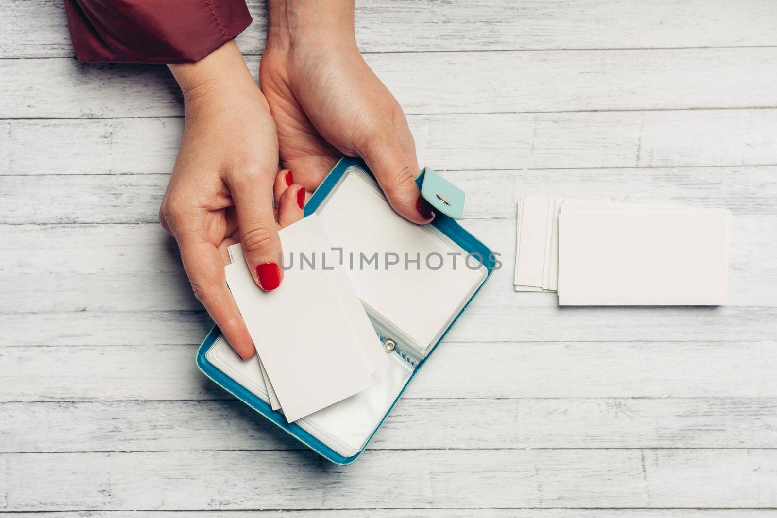open card holder in female hands on a wooden background top view. High quality photo