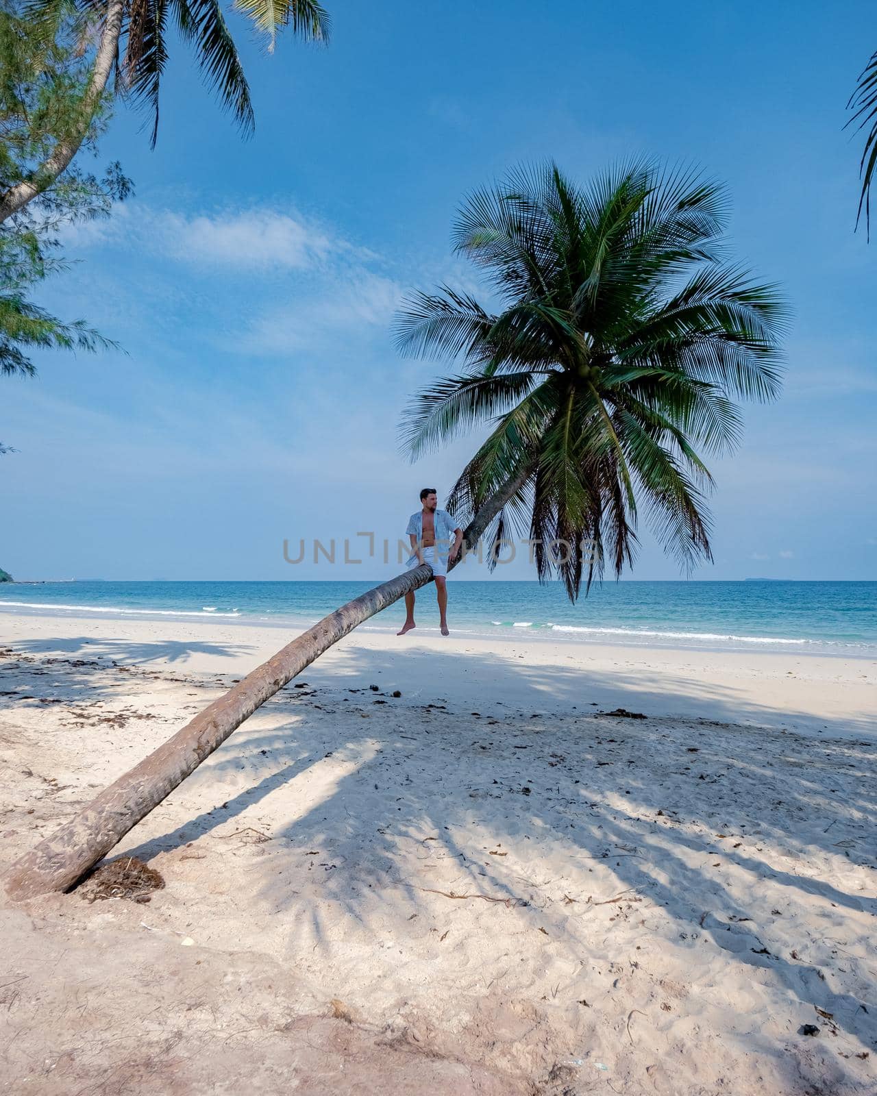 couple on vacation in Thailand, Chumpon province, white tropical beach with palm trees, Wua Laen beach Chumphon area Thailand, palm tree hanging over the beach with a couple on vacation in Thailand.