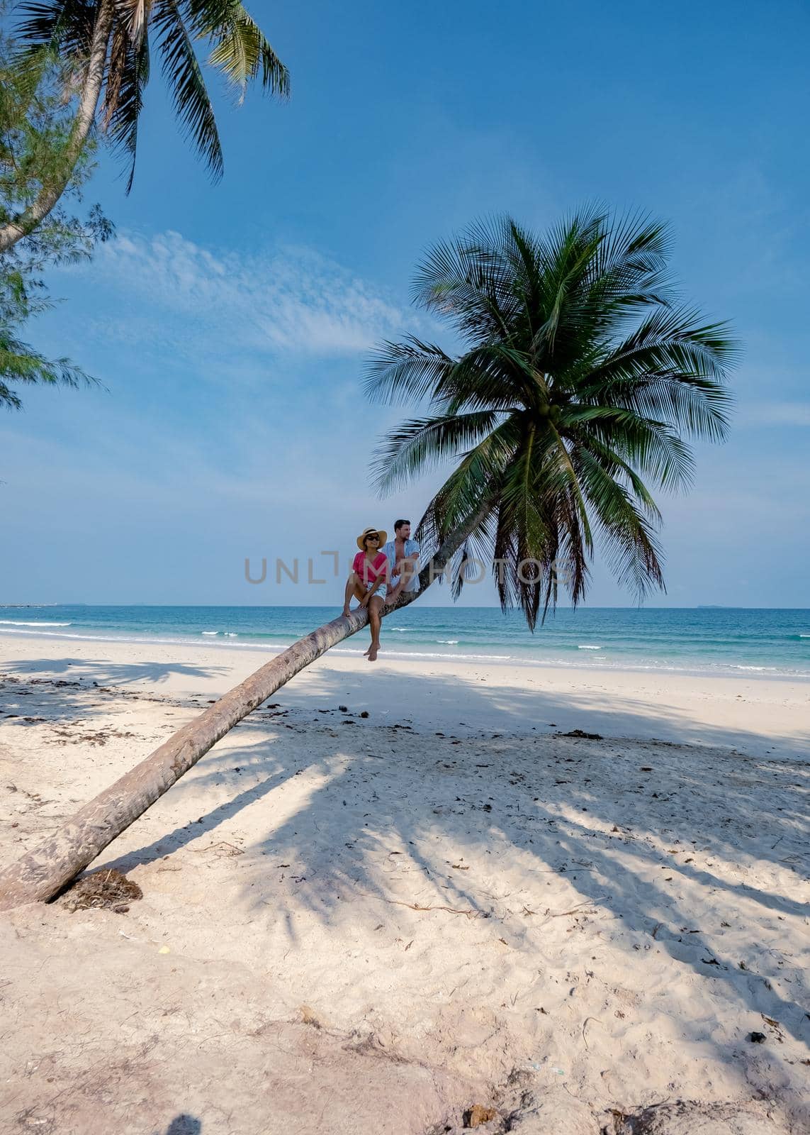 couple on vacation in Thailand, Chumpon province , white tropical beach with palm trees, Wua Laen beach Chumphon area Thailand, palm tree hanging over the beach with couple on vacation in Thailand by fokkebok