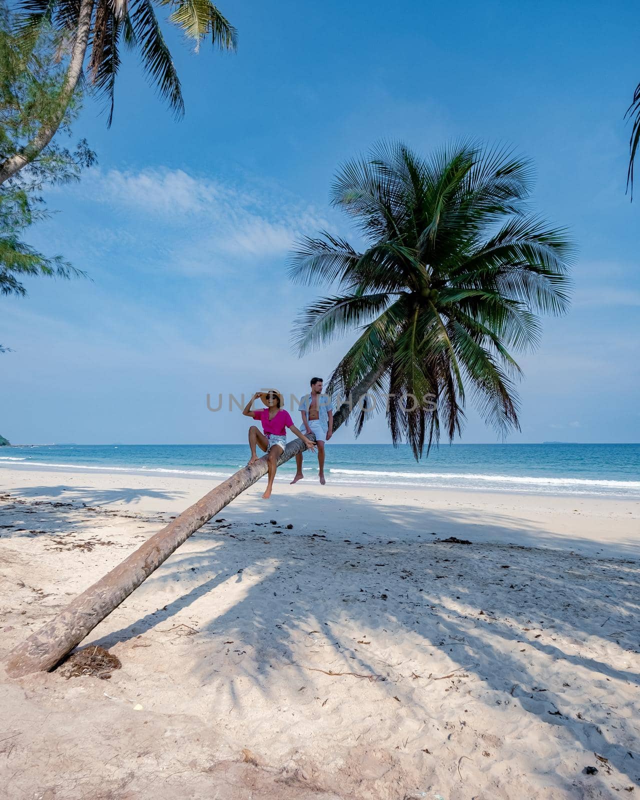couple on vacation in Thailand, Chumpon province , white tropical beach with palm trees, Wua Laen beach Chumphon area Thailand, palm tree hanging over the beach with couple on vacation in Thailand by fokkebok