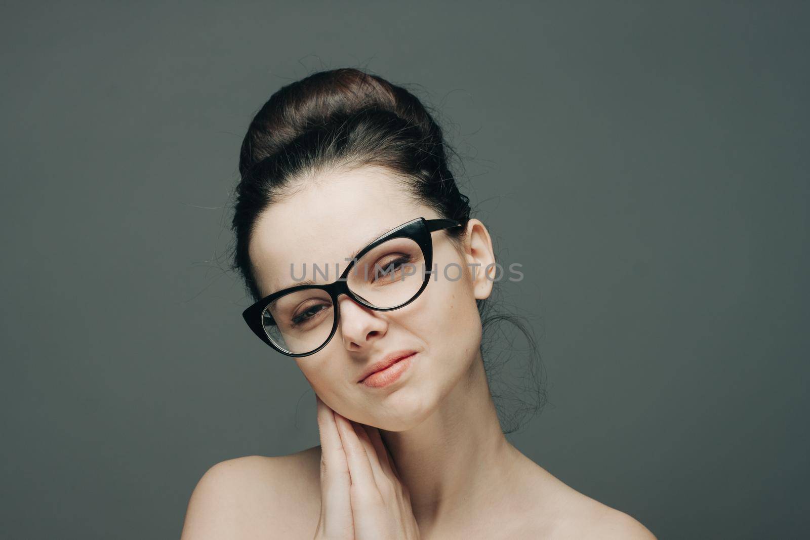 portrait of beautiful brunette woman with bare shoulders fashion hairstyle model cropped view glasses. High quality photo