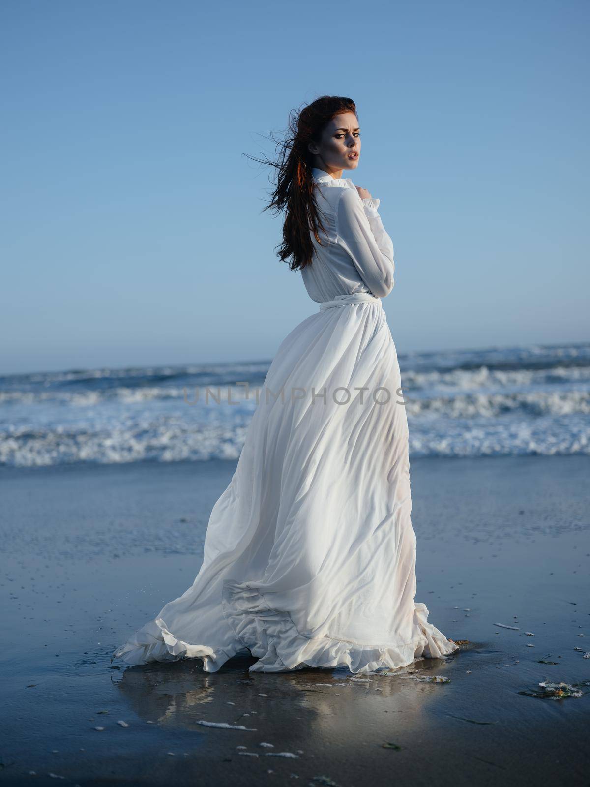 romantic woman in full length sundress by the ocean blue sky beach. High quality photo