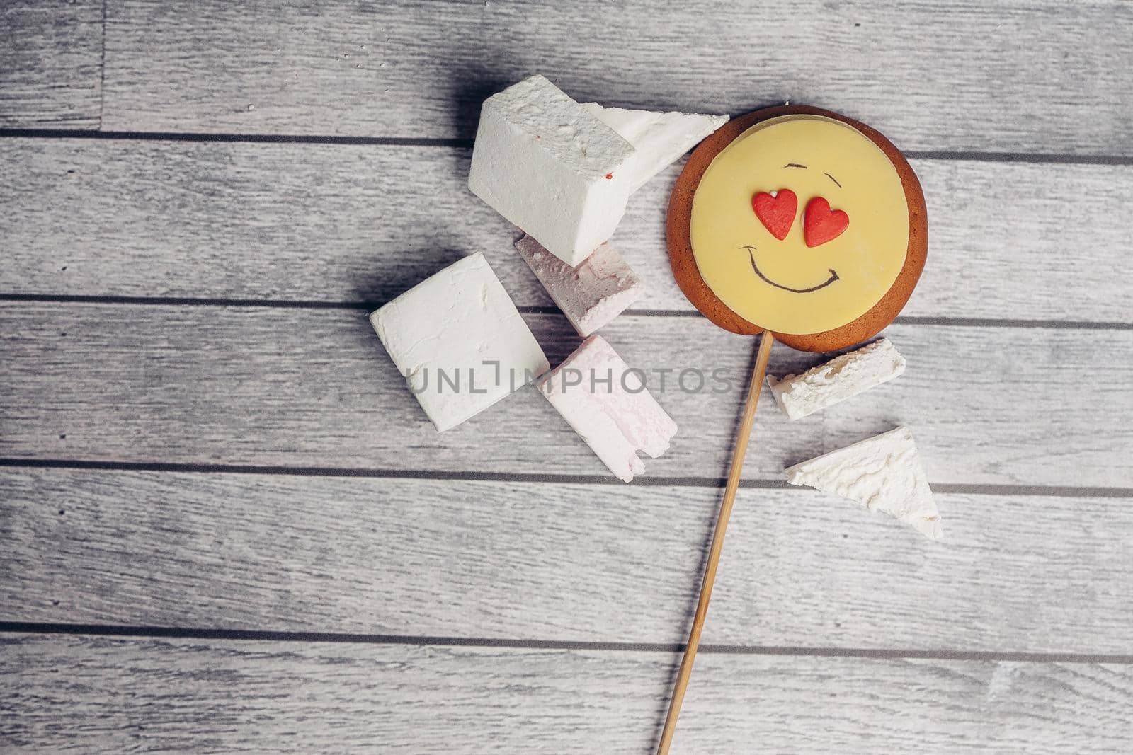 gingerbread in the form of a smiley on a stick marmalade sweets dessert enjoyment wooden background. High quality photo