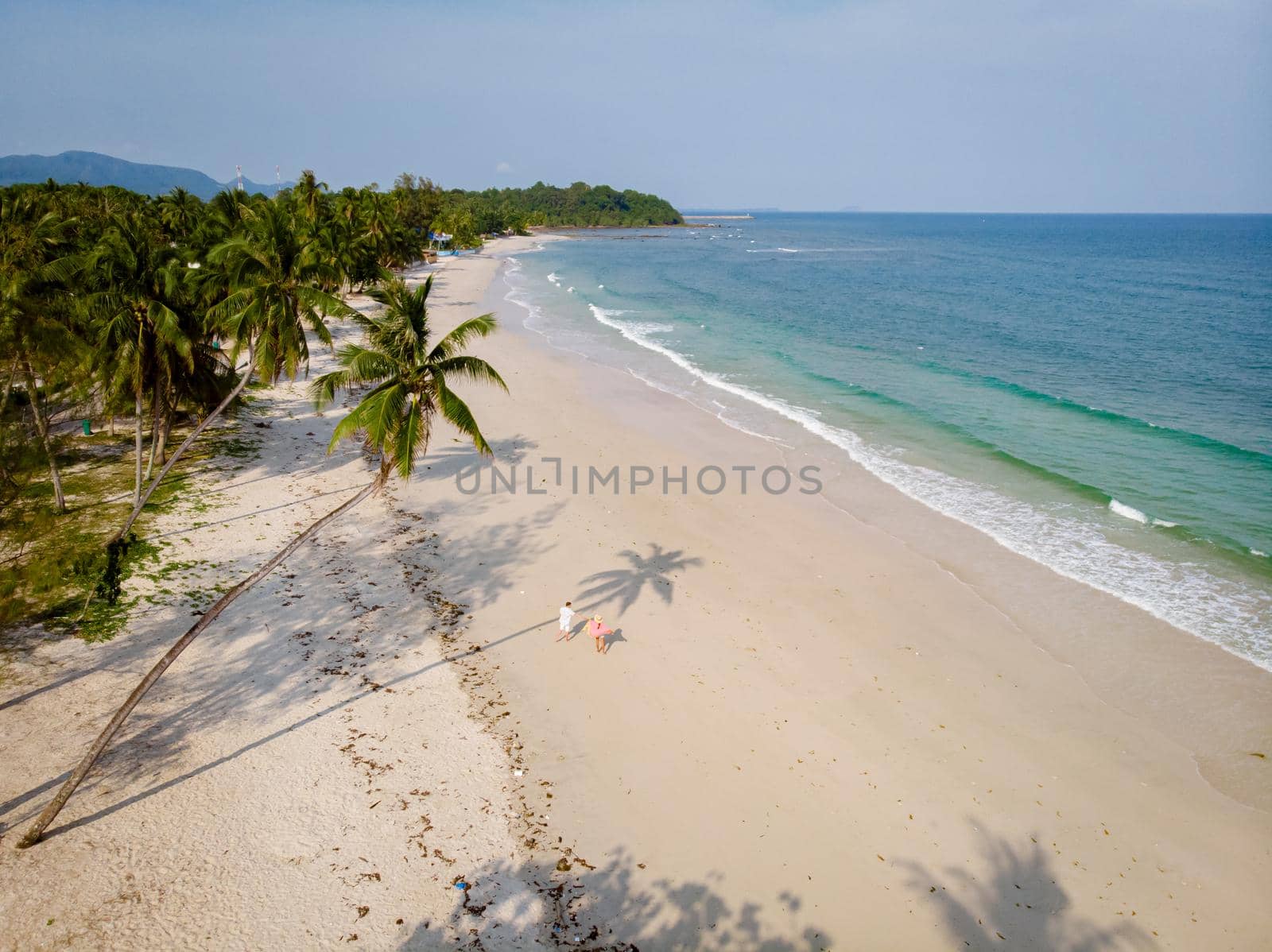 couple on vacation in Thailand, Chumpon province, white tropical beach with palm trees, Wua Laen beach Chumphon area Thailand, palm tree hanging over the beach with a couple on vacation in Thailand.