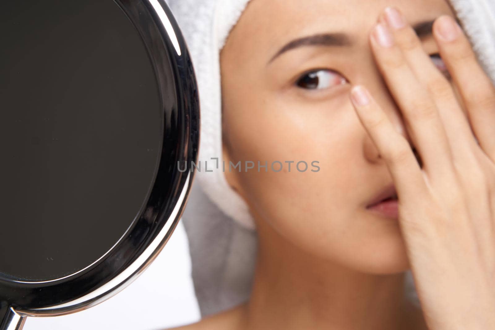 Asian woman looking at the mirror and touching with my hand face clean skin health cosmetology by SHOTPRIME