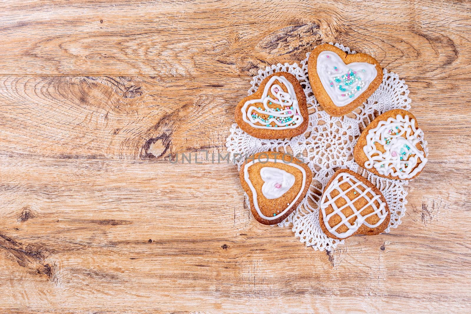 Homemade heart-shaped cookies, decorated with white icing with sprinkles by galinasharapova