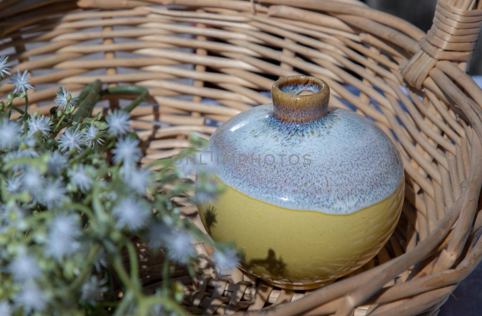 Small  yellow ceramic vases with bouquet of flowers in woven basket. Home decor, Selective focus.