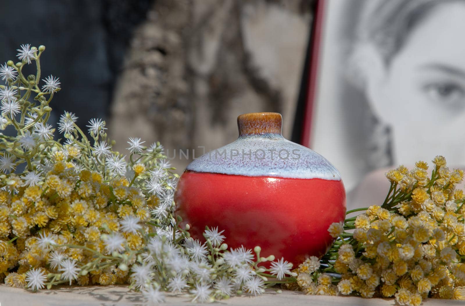 Bangkok, Thailand - Feb 06, 2021: Small red ceramic vases on pink textured table cloth in front of Chinese poster movie frame. Home decor, Selective focus.
