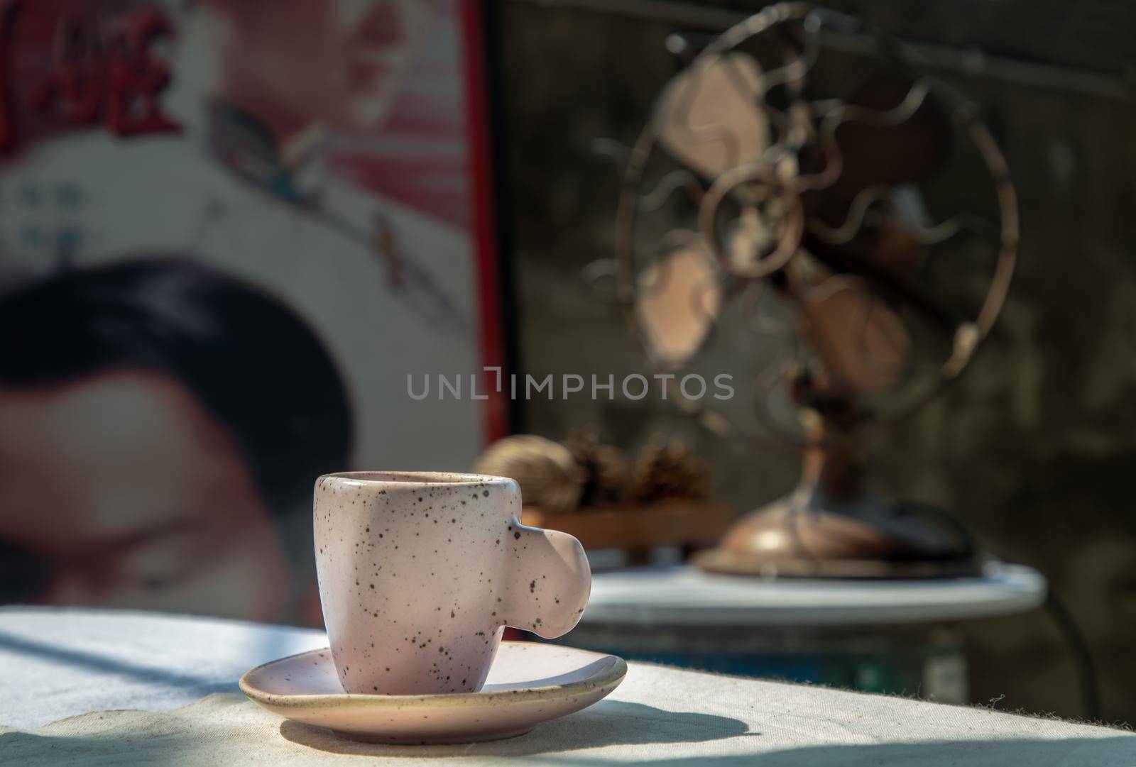 Beautiful pink ceramic mug in Chinese retro style room with old ruins cement wall. No focus, specifically.
