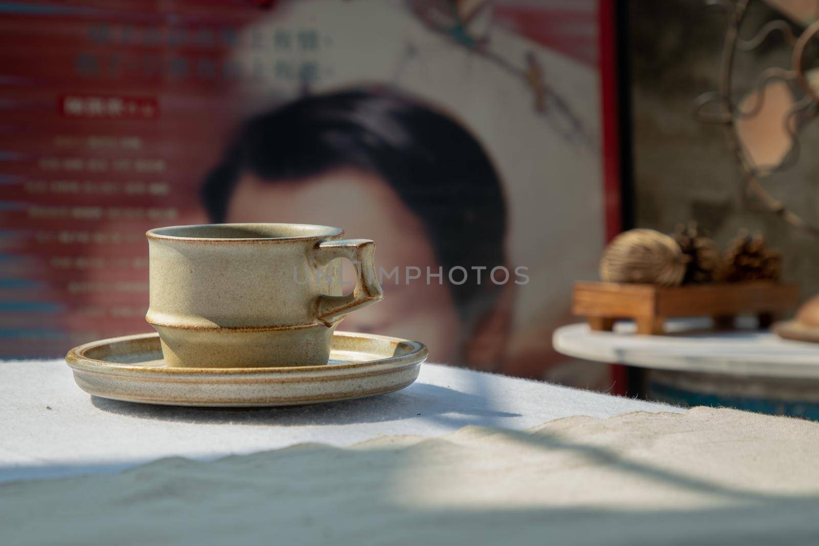 Ceramic mug handmade in Chinese retro style room with old ruins cement wall. Selective focus.