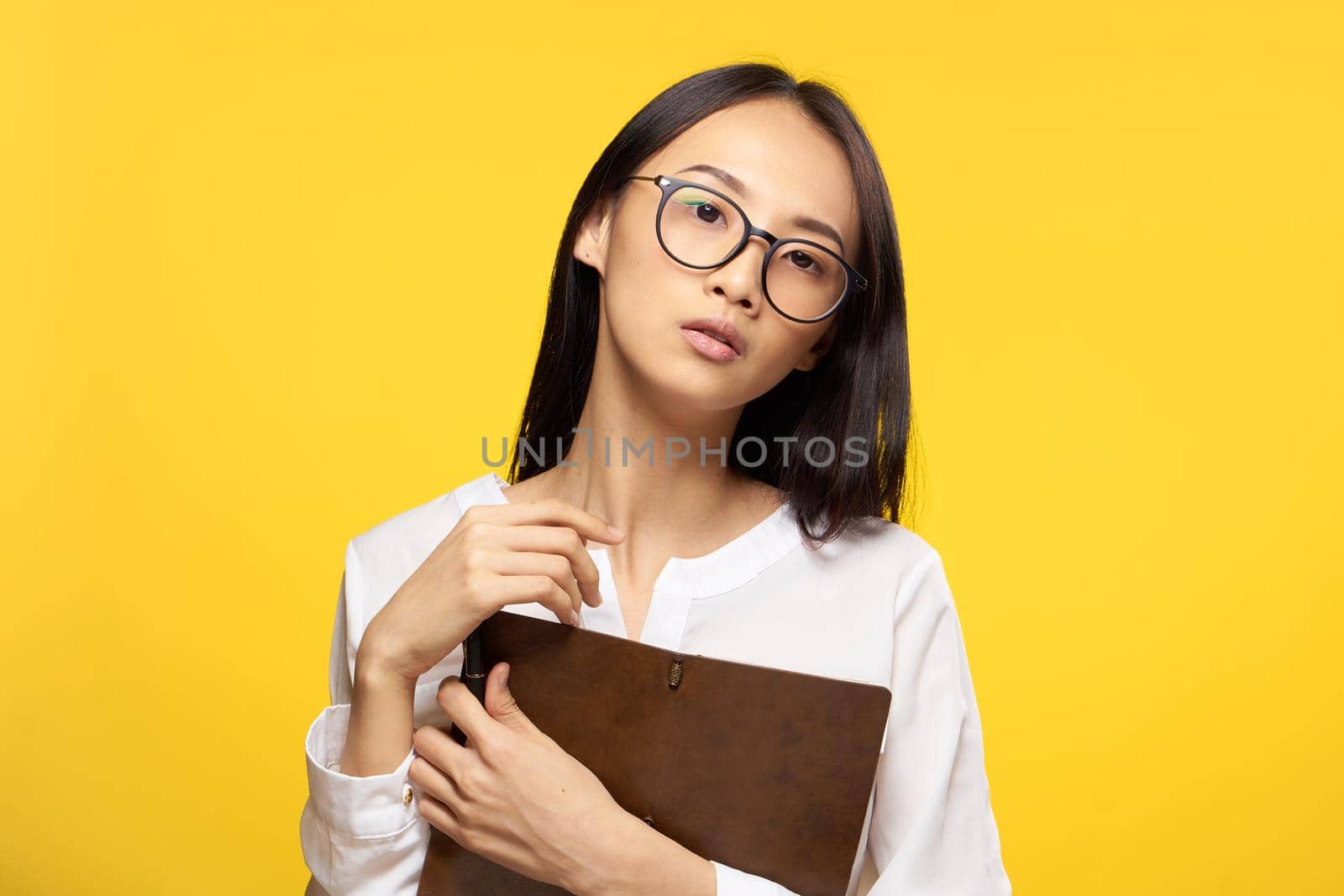 elegant woman with notepad in hands official office yellow isolated background. High quality photo