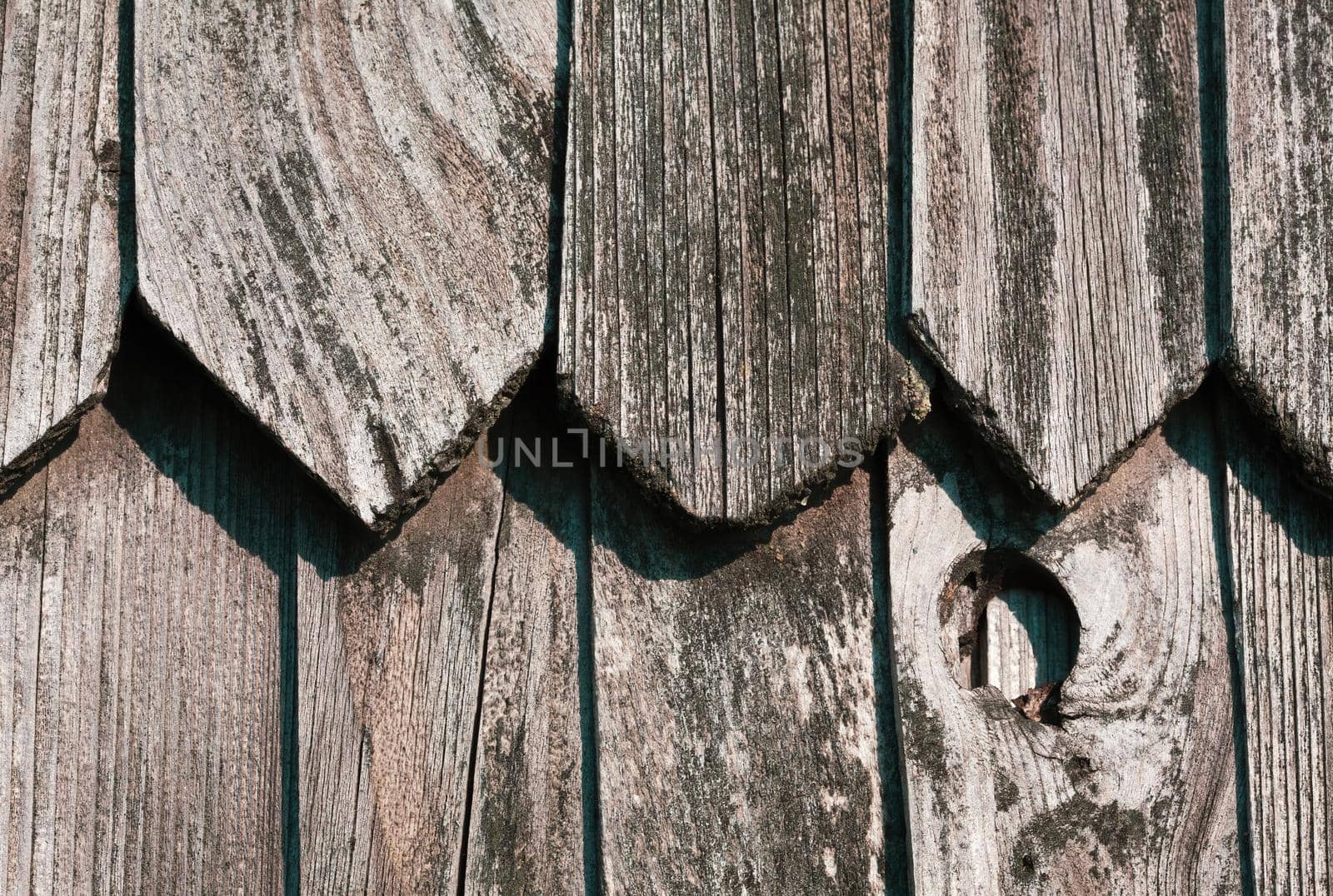 Fragment of the wall of an old rural house made of wooden planks. Background texture of old wooden wall. 