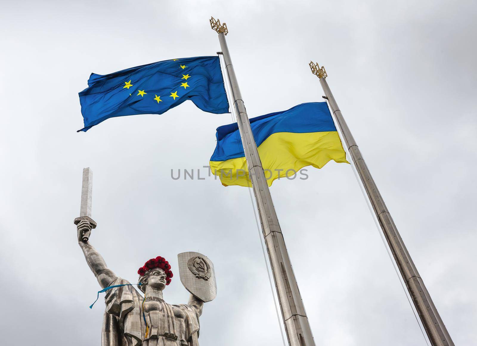KIEV, UKRAINE - May. 08, 2015: Flags of the European Union and Ukraine against monumental statue of the "Mother Motherland" devoted the Great Patriotic War