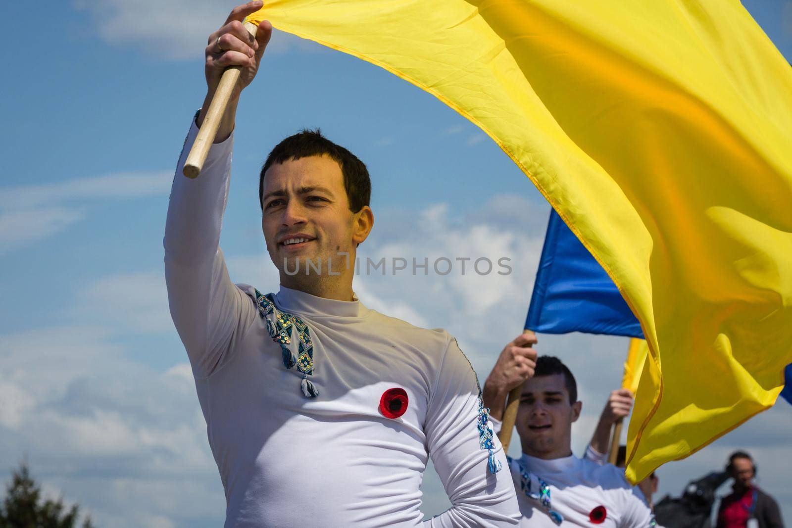 KIEV, UKRAINE - May. 09, 2015: Young people with flags of Ukraine during Victory Day celebrations in the square next to the National Museum of the Great Patriotic War