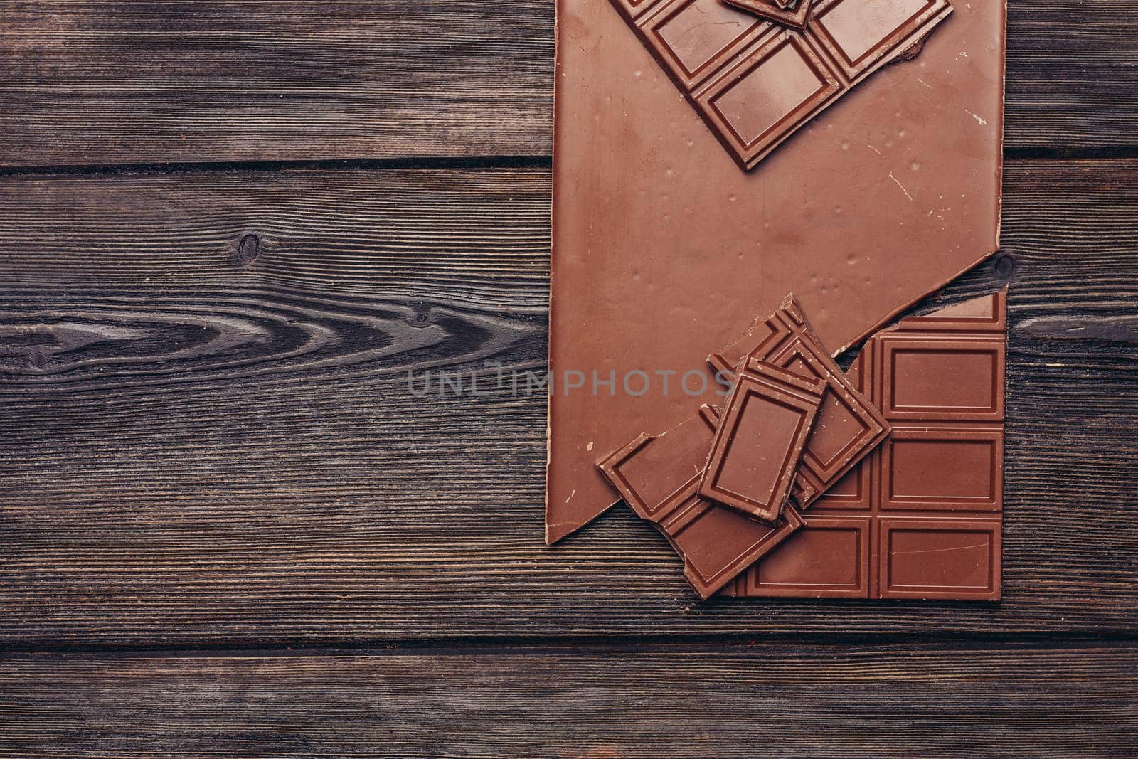sweet chocolate bar on wooden background and sweets candy texture. High quality photo