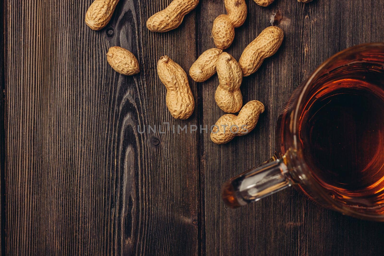 beer mug peanuts in shell wooden table top view. High quality photo
