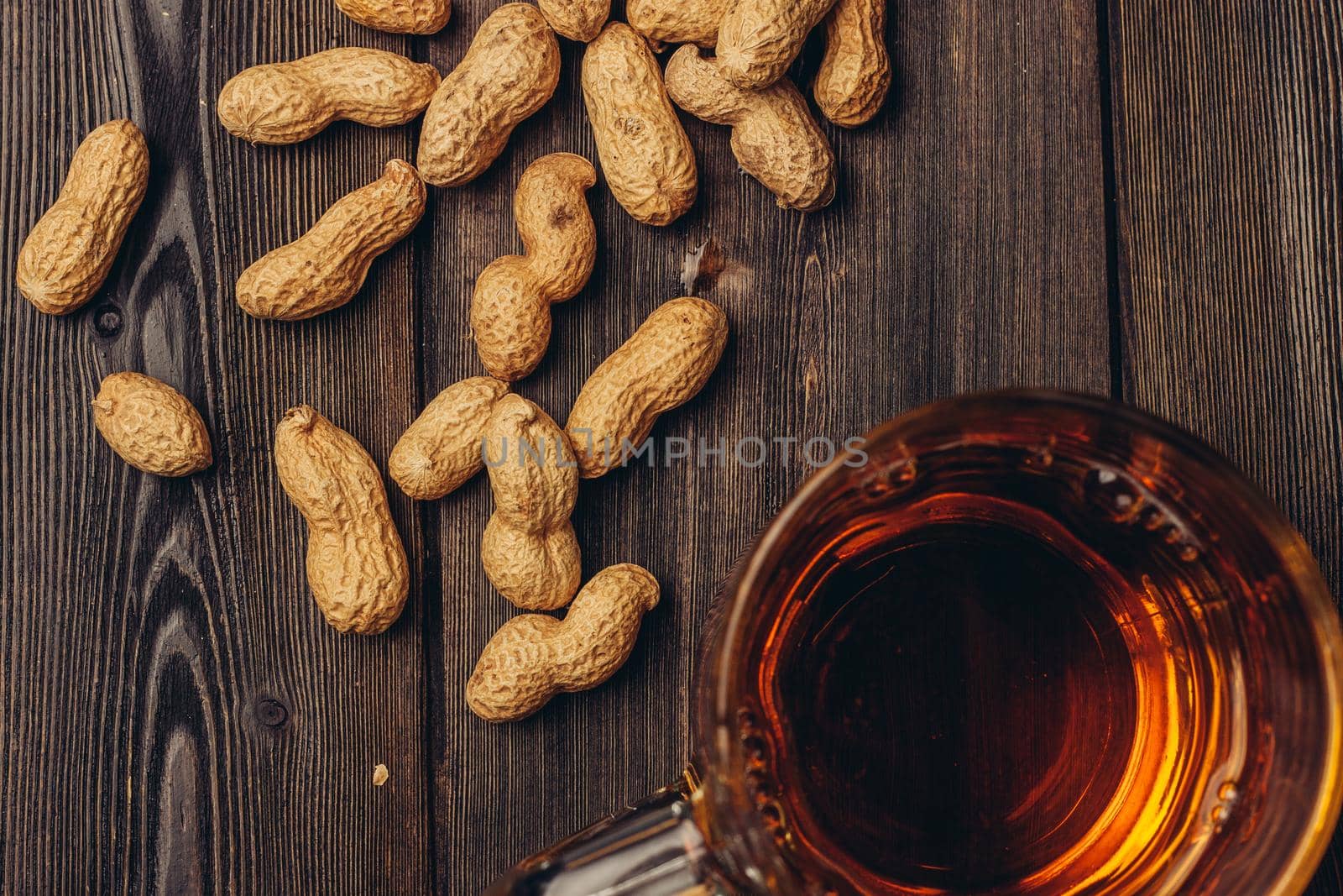 beer mug peanuts in shell wooden table top view. High quality photo