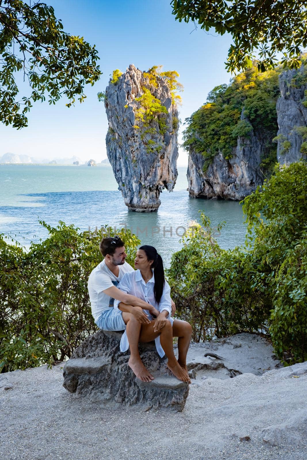 James Bond island near Phuket in Thailand. Famous landmark and famous travel destination, couple men and woman mid age visiting James Bond island in Krabi Thailand. European man and Asian woman on vacation